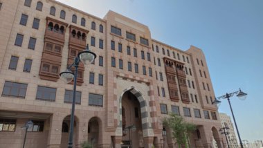 Yukarı bakan modern bir cam ve beton binanın soyut bir görüntüsü. Bir ofis binasının mimari dış görünüşü. Gökyüzüne karşı yükselen yüksek binaları olan bir şehir manzarası.