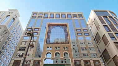 Yukarı bakan modern bir cam ve beton binanın soyut bir görüntüsü. Bir ofis binasının mimari dış görünüşü. Gökyüzüne karşı yükselen yüksek binaları olan bir şehir manzarası.