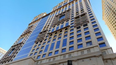 Yukarı bakan modern bir cam ve beton binanın soyut bir görüntüsü. Bir ofis binasının mimari dış görünüşü. Gökyüzüne karşı yükselen yüksek binaları olan bir şehir manzarası.