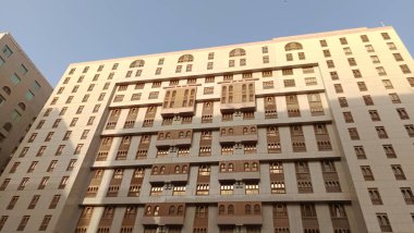 Yukarı bakan modern bir cam ve beton binanın soyut bir görüntüsü. Bir ofis binasının mimari dış görünüşü. Gökyüzüne karşı yükselen yüksek binaları olan bir şehir manzarası.