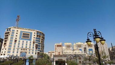 Yukarı bakan modern bir cam ve beton binanın soyut bir görüntüsü. Bir ofis binasının mimari dış görünüşü. Gökyüzüne karşı yükselen yüksek binaları olan bir şehir manzarası.