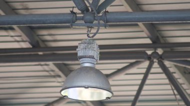 Sahne ışıkları bir spor stadyumunun çelik çerçevesinden sarkıyor.