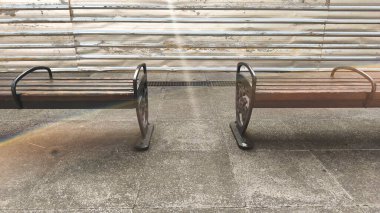 Güneşli bir günde parkta ahşap bir bank.