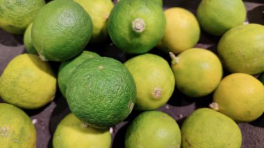 Taze yeşil limonlar, doğal dokular ve canlı turunçgiller, yiyecek, sağlık ve taze üretim kavramları için mükemmel..