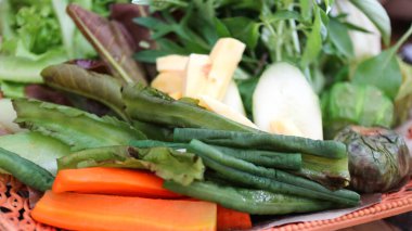 Lalapan veya taze çiğ sebze sepeti. Biber soslu, tamamlayıcı yemek olarak yenir. Bir sepet çiğ sebze otantik Endonezya yemeği.