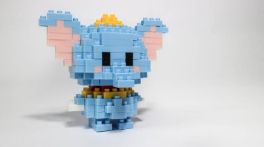 Beyaz arka planda plastik yapı taşlarından yapılmış şirin mavi bir fil figürü. Renkli yapı taşlarıyla yapılmış oyuncak bir fil. Minimalist bir stüdyo resmi..