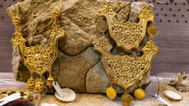 Palembang 'ın geleneksel Asya el sanatlarından esinlenilmiş ayrıntılı kabartmalı desenli dekoratif metal aksesuarlar. Altın metaller, Güney Sumatra 'dan geleneksel Asya mücevherleri..