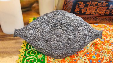 Palembang 'ın geleneksel Asya el sanatlarından esinlenilmiş ayrıntılı kabartmalı desenli dekoratif metal aksesuarlar. Altın metaller, Güney Sumatra 'dan geleneksel Asya mücevherleri..