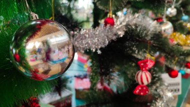 Kırmızı ve altın rengi yakın plan dekore edilmiş bir Noel ağacının arka planı. Kırmızı süslemeli ve kopya alanı olan bir Noel ağacından tebrik kartı..