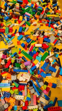 Renkli plastik yapboz blokları beyaz arka plana saçılmış, minimalist düz kompozisyon. Küçük, çok renkli oyuncak blokları temiz beyaz bir yüzeye rastgele dağılır, yaratıcı bir kavram..