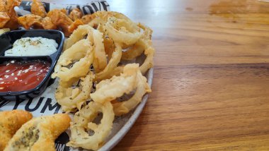 Mix Platter, paket servis yemekleri: mozzarella çubukları, soğan halkaları, patates kızartması, tavuk nugget ve ahşap bir tahtanın üzerindeki sos. afiş, menü, metin için tarif sahibi.