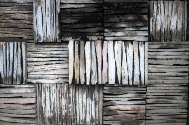 Duvarda granit kaldırım taşlarının yaratıcı şekilleri sıralanmıştır..