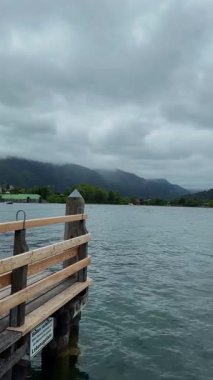 Dağların yakınındaki bir gölde tahta iskele.