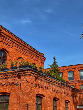 Açık mavi gökyüzü altında tarihi kırmızı tuğla mimari