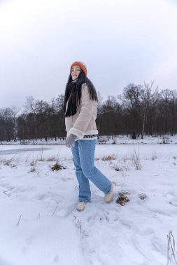 Karlı kış manzarasında yürüyen bir kadın