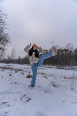 Enerjik kadın kış manzarasında eğleniyor.