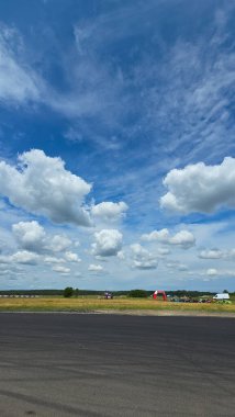 Açık hava olayının olduğu yerin üstünde açık bir gökyüzü bir yarış pisti.