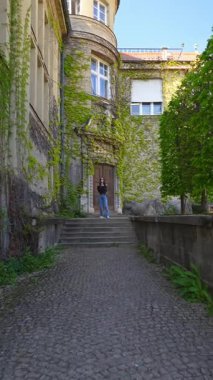 Binanın yanındaki merdivenlerden çıkan kendine güvenen şık bir kadın.