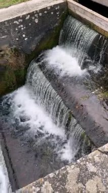 Barajdan bir kanala akan su küçük bir şelale oluşturuyor.