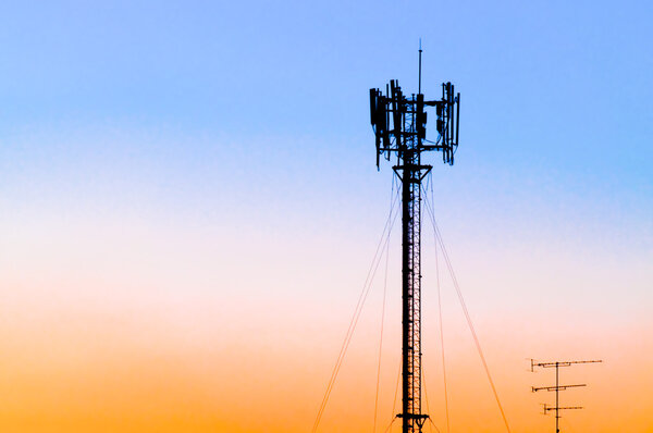 Silhouette of gsm tower against sunset sky
