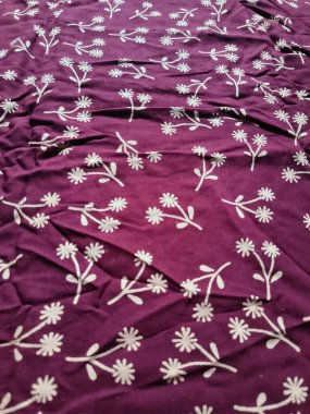 Kumaşın arka planı ve deseni basit bir çiçek resmi ile kırmızıdır.