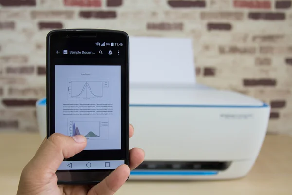 Nahaufnahme eines Geschäftsmannes mit dem Handy zum Drucken von Präsentationsdokumenten — Stockbild Nahaufnahme eines Geschäftsmannes mit dem Handy zum Drucken von Präsentationsdokumenten — Stockfoto