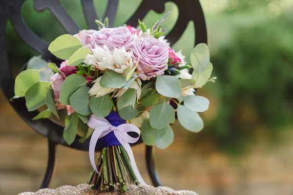 Wedding bouquet of purple, white and pink flowers on the vintage chair — Stock Photo, Image