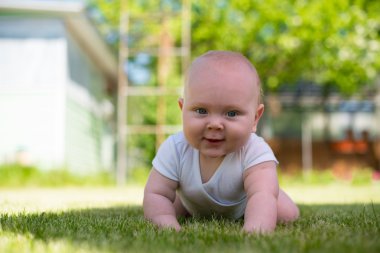 Bebek bahçede çim üzerinde yalan ve gülümseyen