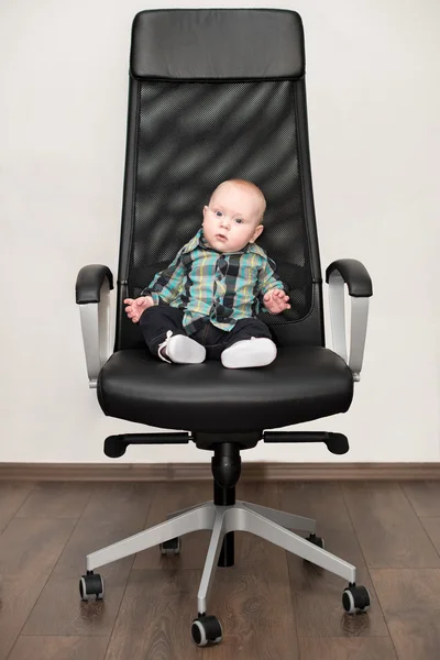 Pequeño niño sentado en una silla grande —  Fotos de Stock