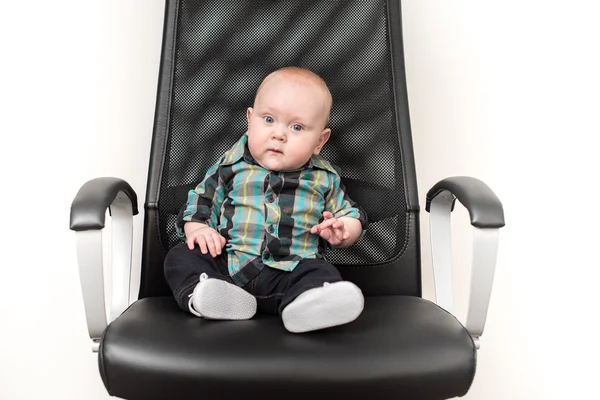 Pequeño niño sentado en una silla grande —  Fotos de Stock