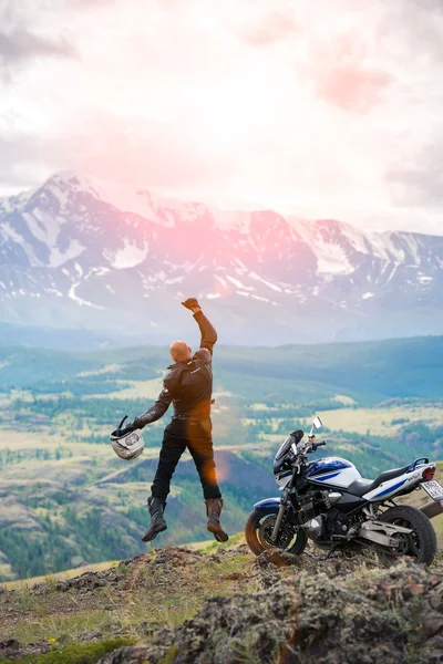 Glatzkopf springt mit erhobener Hand nahe Motorrad auf Hinterrad — Stockfoto