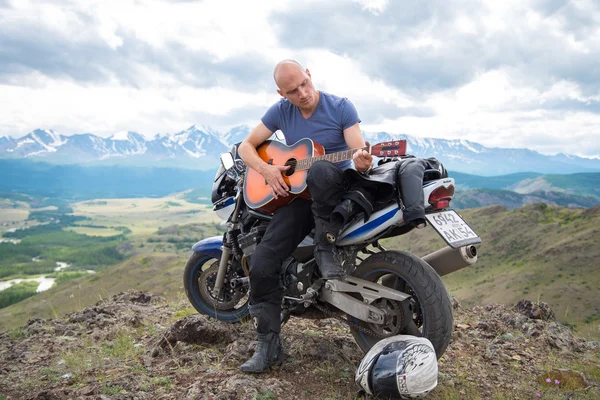 Kel motosikletçi ba bir motosiklet üzerinde oturan gitar çalıyor