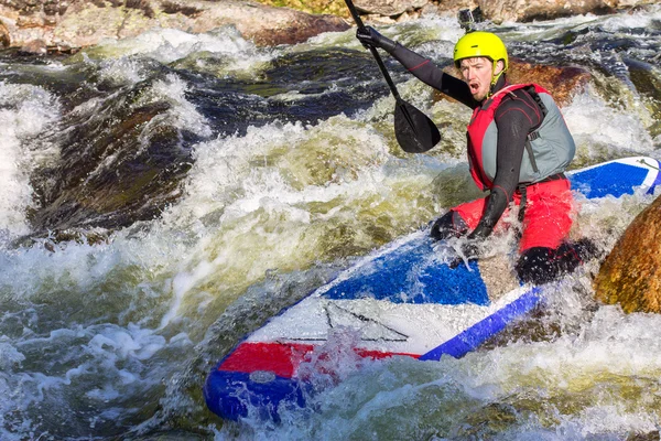 Muž supsurfing v peřejích řeky hory — Stock fotografie