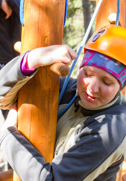 Девушка залезает на канаты
