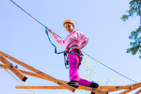 Девушка залезает на канаты
