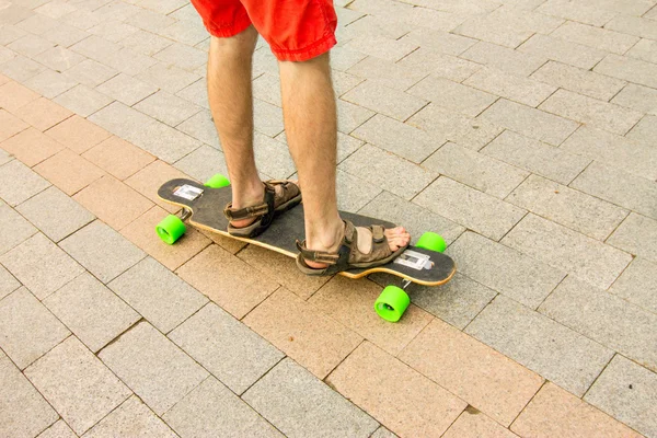 Punto di vista di una persona gamba sul longboard sulla strada della città. P — Foto Stock