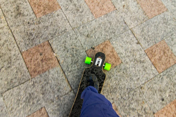 Ponto de vista de uma pessoa perna no longboard na rua da cidade. P — Fotografia de Stock