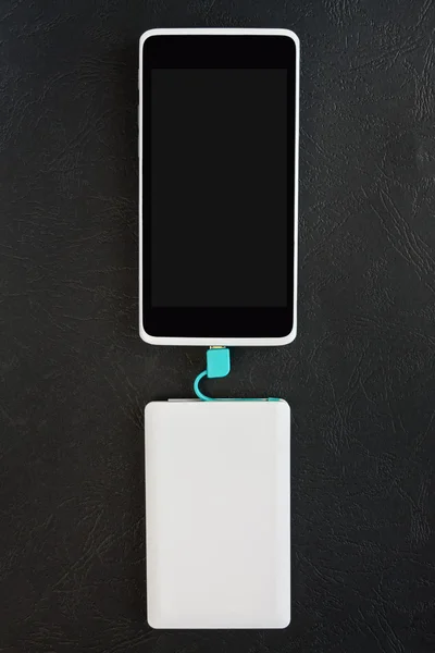 Carga de Smartphone con banco de energía sobre fondo negro — Foto de Stock