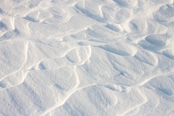 Achtergrond sneeuw golven bij zonsondergang door de wind — Stockfoto