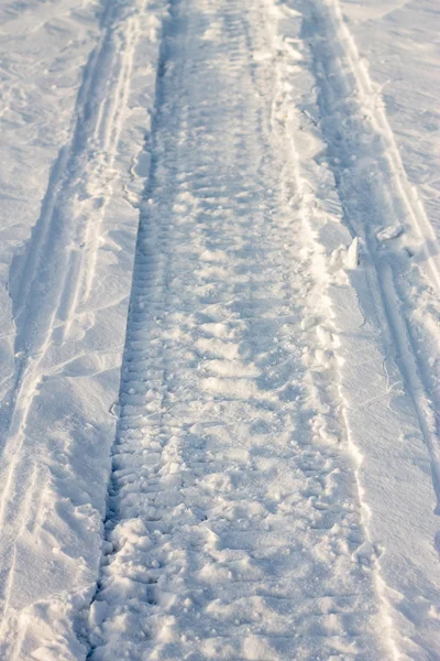 La route dans la neige sur une motoneige au coucher du soleil — Photo