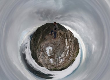 Bir adam dağlarda standları ve mesafe içine yukarıda görünüyor