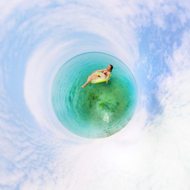 Kız masmavi denizde yüzen şişme ringde