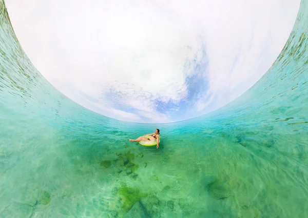 Chica en anillo inflable flotando en el mar azul — Foto de Stock