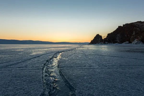 Brede scheur in het ijs van het Baikalmeer bij de sjamaan rots — Stockfoto