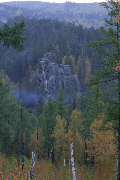 Rock Knight staat in de herfst bos tussen de bomen op sunse — Stockfoto