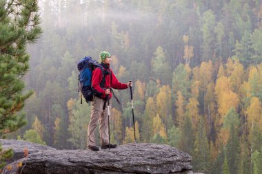 Sırt çantası ve trekking kutubun bir roc bandana ayakta olan adam