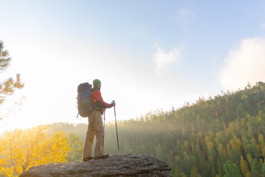 Sırt çantası ve trekking kutubun bir roc bandana ayakta olan adam
