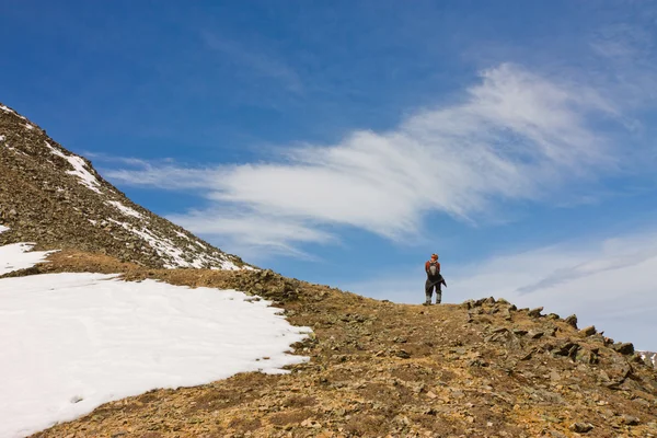 Touristenmann mit Rucksack steht allein im schneebedeckten Wasser — Stockfoto