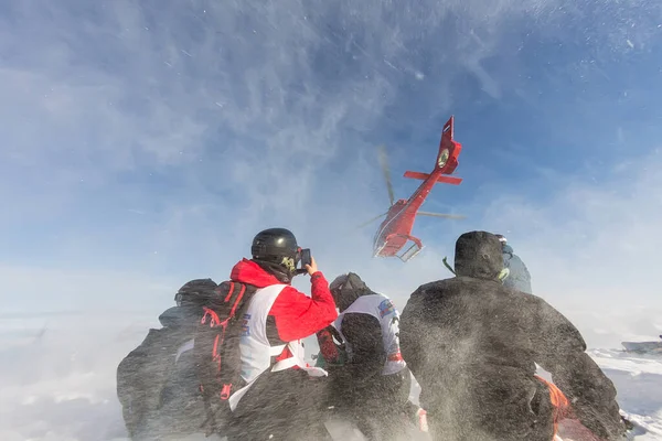 Aterrizando desde el helicóptero esquiadores freeriders en las montañas nevadas en invierno —  Fotos de Stock