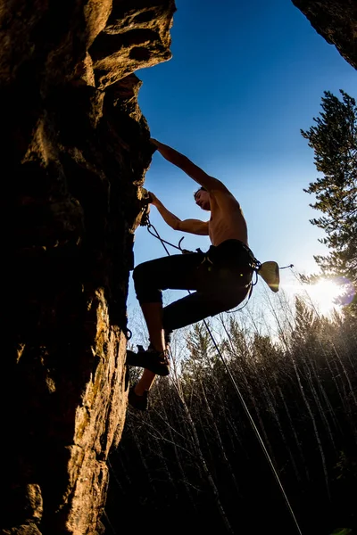 Çıplak gövdeli bir erkek tırmanışçı sigortalı bir kayaya tırmanır. — Stok fotoğraf